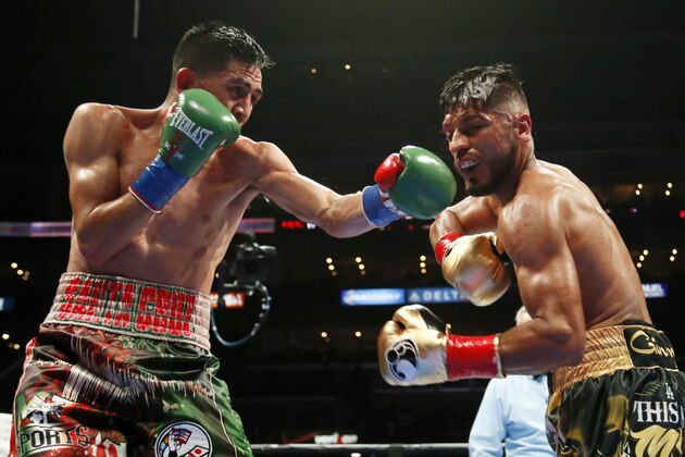 Leo Santa Cruz, left, exchanges punches with Abner Mares during the 11th round of their WBC diamond featherweight and WBA featherweight championship boxing bout, Saturday, Aug. 29, 2015, in Los Angeles. Santa Cruz won with a decision after the 12th round. (AP Photo/Danny Moloshok)