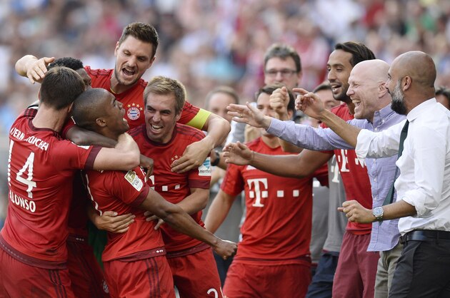 Bayern Munich's Spanish head coach Pep Guardiola (R) celebrates with his players after his team scored the winning goal for Munich's 2-1 victory during the German first division Bundesliga football match 1899 Hoffenheim v FC Bayern Munich, on August 22, 2015 in Sinsheim.   AFP PHOTO / THOMAS KIENZLE 
RESTRICTIONS: DURING MATCH TIME: DFL RULES TO LIMIT THE ONLINE USAGE TO 15 PICTURES PER MATCH AND FORBID IMAGE SEQUENCES TO SIMULATE VIDEO. 
== RESTRICTED TO EDITORIAL USE == FOR FURTHER QUERIES PLEASE CONTACT DFL DIRECTLY AT + 49 69 650050.        (Photo credit should read THOMAS KIENZLE/AFP/Getty Images)