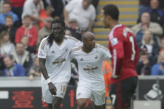 Swansea City's Bafetimbi Gomis, left, celebrates scoring his side's second goal with Andre Ayew beside Manchester United's Memphis Depay during the English Premier League soccer match between Swansea City and Manchester United at the Liberty Stadium in Swansea, Wales, Sunday, Aug. 30, 2015.  (AP Photo/Matt Dunham)
