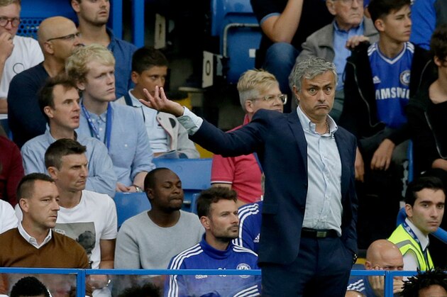 Chelsea's head coach Jose Mourinho gestures as he watches with club captain John Terry, who is suspended sitting bottom left brown jumper, during the English Premier League soccer match between Chelsea and Crystal Palace at Stamford Bridge stadium in London, Saturday, Aug. 29, 2015.  (AP Photo/Matt Dunham)