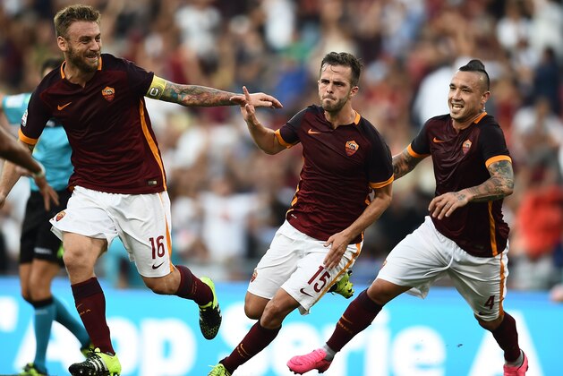 Roma's midfielder from Bosnia-Herzegovina Miralem Pjanic (C) celebrates with Roma's midfielder from Belgium Radja Nainggolan (R) and Roma's midfielder from Italy Daniele De Rossi after scoring during the Italian Serie A football match AS Roma vs Juventus on August 30, 2015 at the Olympic stadium in Rome.    AFP PHOTO / FILIPPO MONTEFORTE        (Photo credit should read FILIPPO MONTEFORTE/AFP/Getty Images)