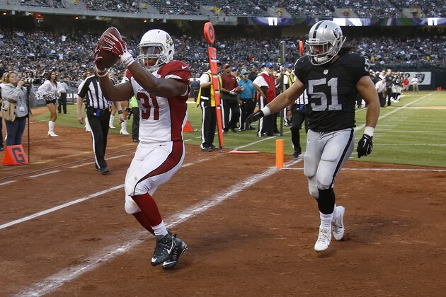 Arizona Cardinals running back David Johnson (31) reacts after catching a touchdown pass in front of Oakland Raiders inside linebacker Ben Heeney (51) during the second half of an NFL preseason football game in Oakland, Calif., Sunday, Aug. 30, 2015. (AP Photo/Tony Avelar)