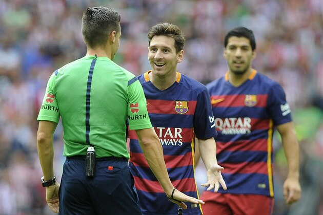 Barcelona's Argentinian forward Lionel Messi (C) speaks with the referee during the Spanish league football match Athletic Club Bilbao vs FC Barcelona at the San Mames stadium in Bilbao on August 23, 2015.  AFP PHOTO / ANDER GILLENEA        (Photo credit should read ANDER GILLENEA/AFP/Getty Images)