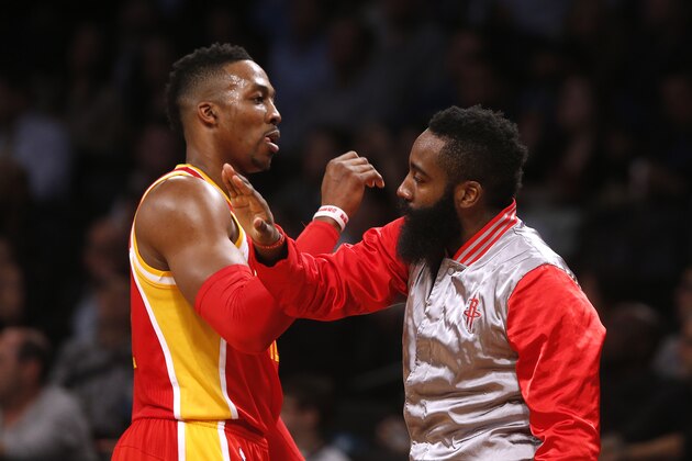 Houston Rockets' Dwight Howard, left, celebrates with teammate James Harden during the second quarter of an NBA basketball game against the Brooklyn Nets Monday, Jan. 12, 2015, in New York.  Houston beat Brooklyn 113-99. (AP Photo/Jason DeCrow)