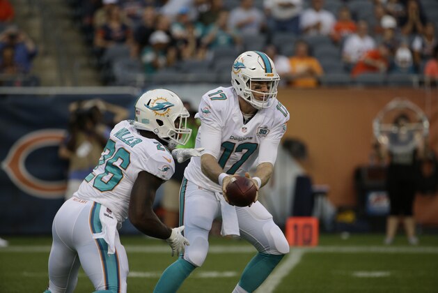 Miami Dolphins quarterback Ryan Tannehill (17) hands off to running back Lamar Miller (26) in the first half of an NFL preseason football game against the Chicago Bears in Chicago, Thursday, Aug. 13, 2015. (AP Photo/Nam Y. Huh)