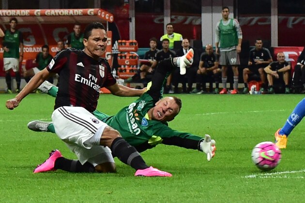 AC Milan's forward from Colombia Carlos Bacca (L) kicks and scores against Empoli's goalkeeper from Poland Lukasz Skorupski during the Italian Serie A football match between AC Milan and Empoli  at San Siro Stadium in Milan on August 29, 2015. AFP PHOTO / GIUSEPPE CACACE        (Photo credit should read GIUSEPPE CACACE/AFP/Getty Images)