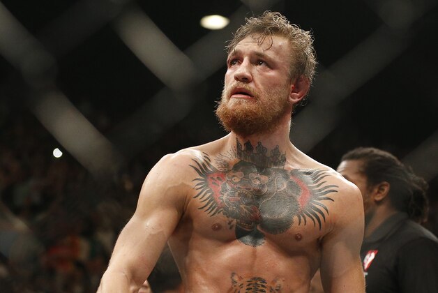 Conor McGregor celebrates after defeating Chad Mendes during their interim featherweight title mixed martial arts bout at UFC 189 Saturday, July 11, 2015, in Las Vegas. (AP Photo/John Locher)