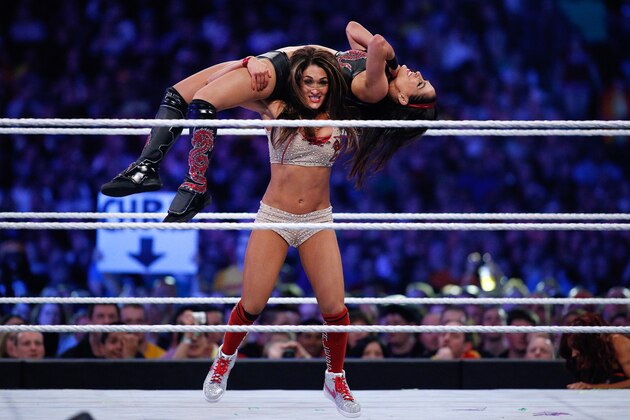 Brie Bella and Nikki Bella, known as the Bella Twins, compete during Wrestlemania XXX at the Mercedes-Benz Super Dome in New Orleans on Sunday, April 6, 2014. (Jonathan Bachman/AP Images for WWE)