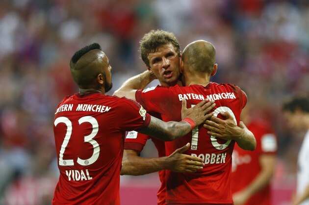 Bayern's Arjen Robben, right, celebrates with teammates Thomas Mueller, center, and Arturo Vidal after scoring his side's third goal from the penalty spot during the German Bundesliga soccer match between FC Bayern Munich and Bayer Leverkusen 04 in Munich, Germany, Saturday, Aug. 29, 2015. (AP Photo/Matthias Schrader)