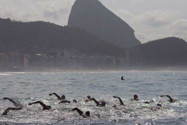 FILE -In this Aug. 22, 2015 file photo, backdropped by Sugar Loaf Mountain, athletes compete in the men's marathon swimming test event, ahead of the Rio 2016 Olympic Games, off Copacabana Beach, Rio de Janeiro, Brazil. Rio's sewage-filled waters are more than just a health risk. For open-water swimmers at the Olympics next year on famous Copacabana Beach, avoiding the bacteria and viruses will become part of the race strategy and could determine who gets a medal, and who doesn't. (AP Photo/Leo Correa, File)