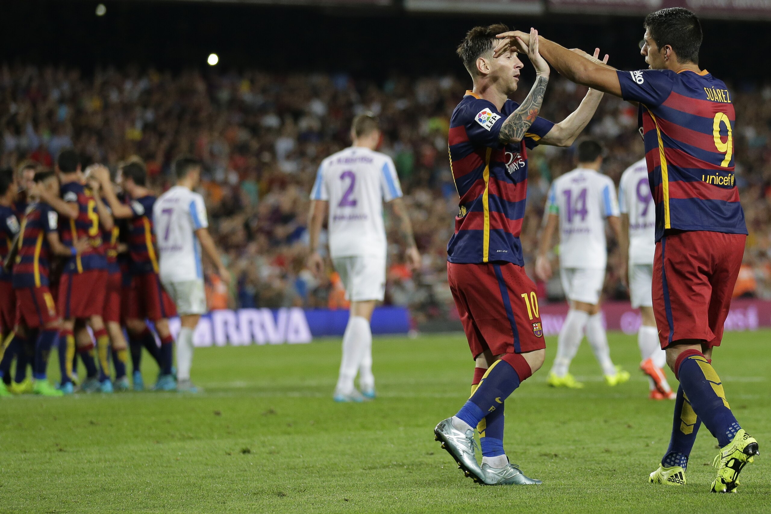 FC Barcelona's Lionel Messi, from Argentina, second right, celebrates with his teammate Luis Suarez, from Uruguay, after Thomas Vermaelen scored against Malaga during a Spanish La Liga soccer match at the Camp Nou stadium in Barcelona, Spain, Saturday, Aug. 29, 2015. (AP Photo/Manu Fernandez) FC Barcelona's Lionel Messi, from Argentina, second right, celebrates with his teammate Luis Suarez, from Uruguay, after Thomas Vermaelen scored against Malaga during a Spanish La Liga soccer match at the Camp Nou stadium in Barcelona, Spain, Saturday, Aug. 29, 2015. (AP Photo/Manu Fernandez)