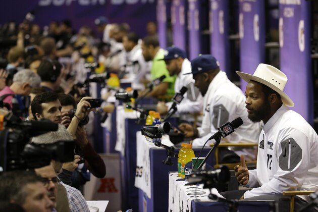 Seattle Seahawks' Michael Bennett, right, answers questions with teammates during media day for NFL Super Bowl XLIX football game Tuesday, Jan. 27, 2015, in Phoenix. (AP Photo/Charlie Riedel)