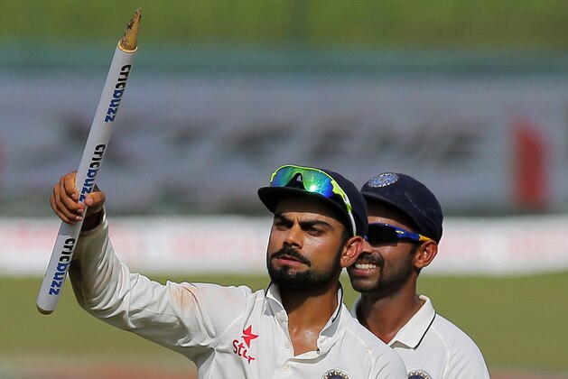 India's captain Virat Kohli, left, holds a stump as he walks off the pitch after defeating Sri Lanka in their third test cricket match in Colombo, Sri Lanka, Tuesday, Sept. 1, 2015. India won by 117 runs. (AP Photo/Eranga Jayawardena)