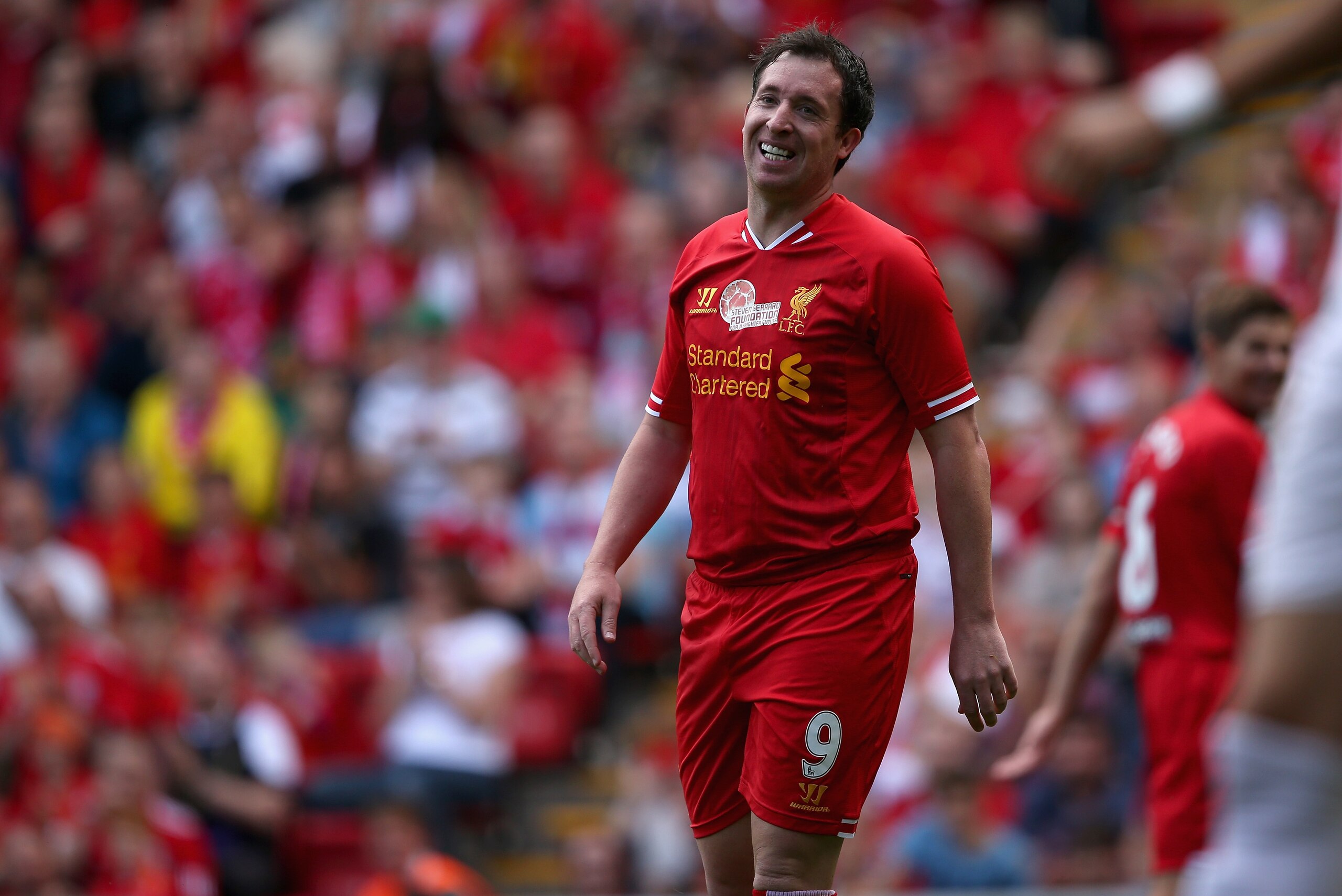 LIVERPOOL, ENGLAND - AUGUST 03: Robbie Fowler of Liverpool in good spirits after a near miss provided by Steven Gerrard  during the Steven Gerrard Testimonial Match between Liverpool and Olympiacos at Anfield on August 03, 2013 in Liverpool, England. (Photo by Clive Brunskill/Getty Images)