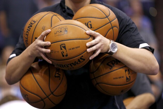 A Phoenix Suns ball boy gathers up the basketballs prior to an NBA basketball game against the Sacramento Kings Wednesday, Nov. 20, 2013, in Phoenix.  The Kings defeated the Suns 113-106. (AP Photo/Ross D. Franklin)