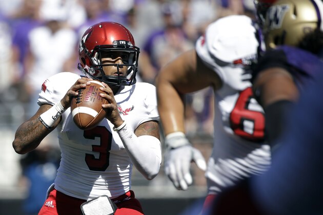 FILE - In this Sept. 6, 2014, file photo, Eastern Washington quarterback Vernon Adams Jr.,left, looks to throw against Washington during the second half of an NCAA football game in Seattle. Adams, one of the best players in FCS, is considering a transfer to Oregon, where he could replace Marcus Mariota next season. Graduate transfer quarterbacks often create a stir but while fans hope they're getting the next Russell Wilson there is no guarantee the next guy makes an impact. (AP Photo/Elaine Thompson, File)
