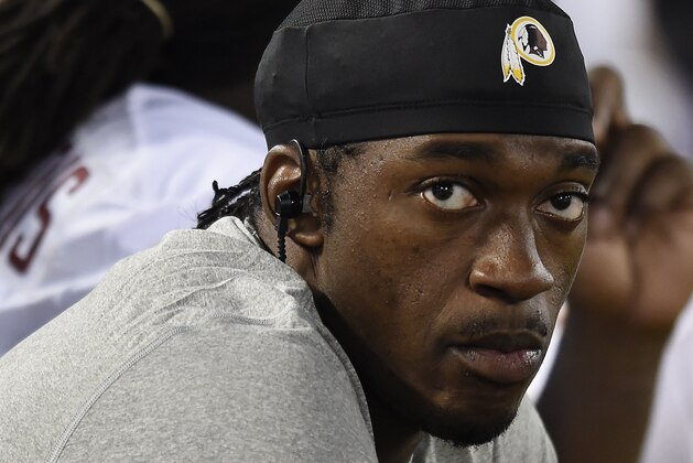 Washington Redskins quarterback Robert Griffin III sits on the sideline in the second half of a preseason NFL football game against the Baltimore Ravens, Saturday, Aug. 29, 2015, in Baltimore. (AP Photo/Gail Burton)