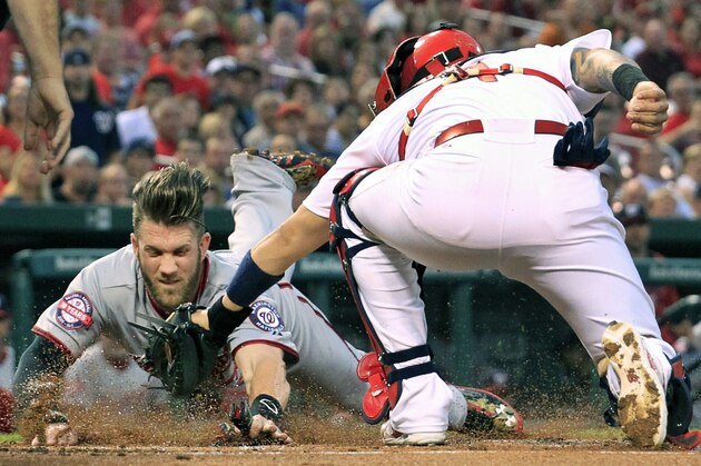 Washington Nationals' Bryce Harper, left, scores ahead of the tag from St. Louis Cardinals catcher Yadier Molina during the first inning of a baseball game Monday, Aug. 31, 2015, in St. Louis. (AP Photo/Jeff Roberson)