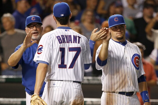Chicago Cubs manager Joe Maddon, left, and Kyle Schwarber, right, celebrate the Cubs' 5-4 win over the Cincinnati Reds with Kris Bryant (17) after a baseball game Tuesday, Sept. 1, 2015, in Chicago. (AP Photo/Charles Rex Arbogast)