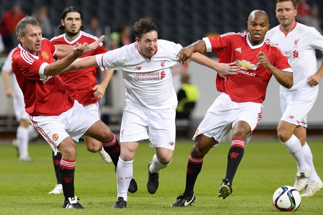 Robbie Fowler (C) of Liverpool vies with Bryan Robson (L) and Quinton Fortune of Manchester United during the charity football match Manchester United Legends vs Liverpool Legends at the Friends arena in Solna, near Stockholm on September 3, 2015. AFP PHOTO/JONATHAN NACKSTRAND        (Photo credit should read JONATHAN NACKSTRAND/AFP/Getty Images)