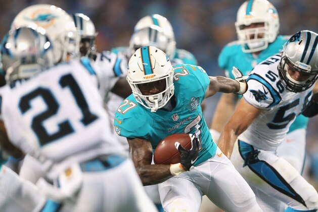 CHARLOTTE, NC - AUGUST 22:  LaMichael James #27 of the Miami Dolphins runs with the ball against the Carolina Panthers during their game at Bank of America Stadium on August 22, 2015 in Charlotte, North Carolina.  (Photo by Streeter Lecka/Getty Images)