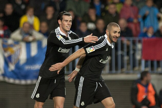 Real Madrid's French forward Karim Benzema (R) celebrates with Welsh forward Gareth Bale after scoring during the Spanish league football match Malaga CF vs Real Madrid CF at the Rosaleda stadium in Malaga on November 29, 2014.   AFP PHOTO/ JORGE GUERRERO        (Photo credit should read Jorge Guerrero/AFP/Getty Images)