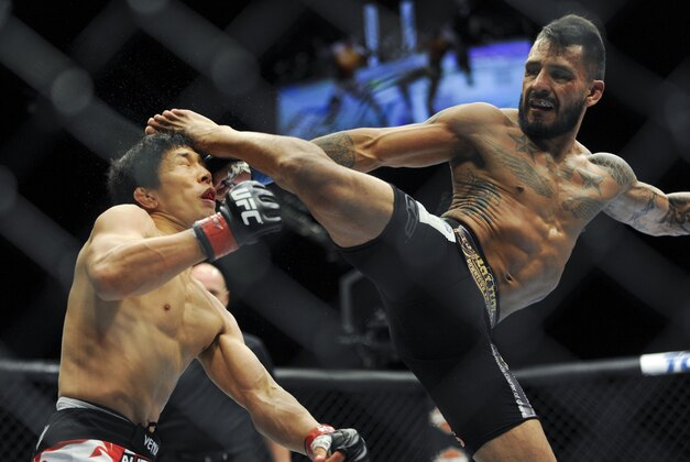 May 24, 2014; Las Vegas, NV, USA; Takeya Mizugaki (red) gets kicked in the head by Francisco Rivera (blue) during their UFC 173 bantamweight bout at MGM Grand Garden Arena. Mizugaki won the bout by unanimous decision. Mandatory Credit: Stephen R. Sylvanie-USA TODAY Sports May 24, 2014; Las Vegas, NV, USA; Takeya Mizugaki (red) gets kicked in the head by Francisco Rivera (blue) during their UFC 173 bantamweight bout at MGM Grand Garden Arena. Mizugaki won the bout by unanimous decision. Mandatory Credit: Stephen R. Sylvanie-USA TODAY Sports