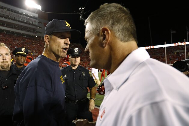 Sep 3, 2015; Salt Lake City, UT, USA; Michigan Wolverines head coach Jim Harbaugh (left) and Utah Utes head coach Kyle Whittingham get together after their game at Rice-Eccles Stadium. Utah won 24-17. Mandatory Credit: Jeff Swinger-USA TODAY Sports
