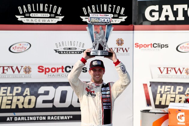 DARLINGTON, SC - SEPTEMBER 05:  Denny Hamlin, driver of the #20 Sport Clips Toyota, lifts the trophy in Victory Lane after winning the NASCAR XFINITY Series VFW Sport Clips Help A Hero 200 at Darlington Raceway on September 5, 2015 in Darlington, South Carolina.  (Photo by Matt Sullivan/Getty Images)