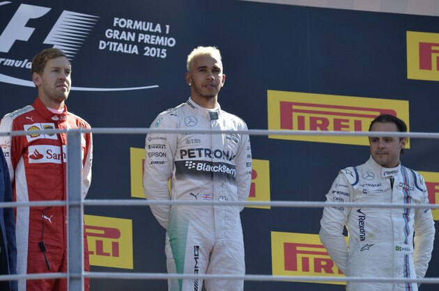 Mercedes AMG Petronas F1 Team's British driver Lewis Hamilton (C) celebrates winning next to second placed (L) Ferrari's German driver Sebastian Vettel and third placed (R) Williams Martini Racing's Brazilian driver Felipe Massa after the Italian Formula One Grand Prix at the Autodromo Nazionale circuit in Monza on September 6, 2015.  AFP PHOTO / ANDREAS SOLARO        (Photo credit should read ANDREAS SOLARO/AFP/Getty Images)