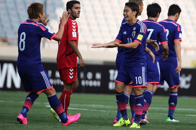 Japan's midfielder Genki Haraguchi (L) and midfielder Shinji Kagawa (R) celebrate scoring a goal against Afghanistan's team at the Azadi stadium in Tehran, during the AFC 2018 FIFA World Cup qualifying football match between Japan and Afghanistan, on September 8, 2015. AFP PHOTO / ATTA KENARE        (Photo credit should read ATTA KENARE/AFP/Getty Images)