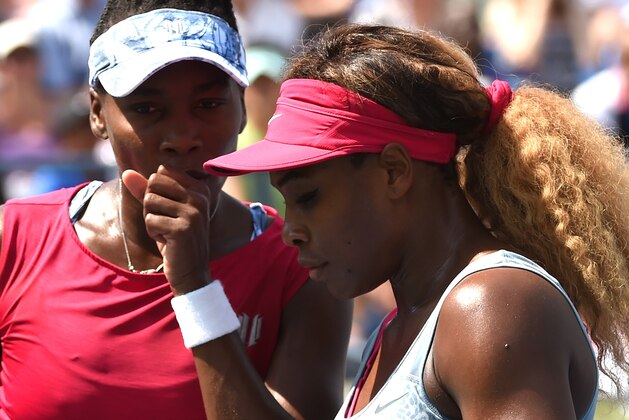 Venus and Serena(R) Williams of the US discuss strategy while playing Ekaterina Makarova and Elena Vesnina of Russia during their 2014 US Open  Women's Doubles - Quarterfinals match at the USTA Billie Jean King National Tennis Center September 2, 2014 in New York.    AFP PHOTO /  TIMOTHY  A. CLARY        (Photo credit should read TIMOTHY A. CLARY/AFP/Getty Images)