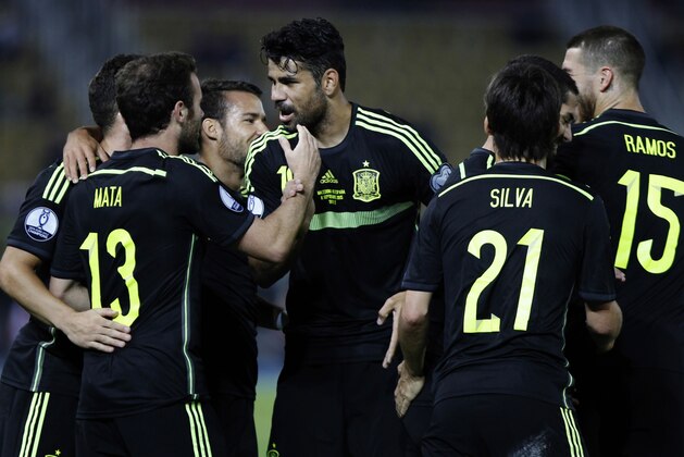 Spain's Juan Mata, left, is congratulated by his teammates after scoring the opening goal against Macedonia during the Euro 2016 qualifying match between Macedonia and Spain at the Philip II stadium, in Skopje, Tuesday, Sept. 8, 2015. (AP Photo/Vlatko Perkovski)
