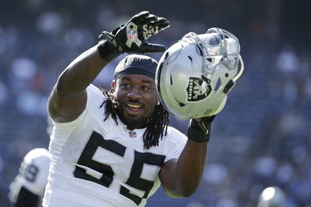 Oakland Raiders linebacker Sio Moore gets involved with fans during warmups prior to an NFL football game against the San Diego Chargers Sunday, Nov. 16, 2014, in San Diego. (AP Photo/Gregory Bull)