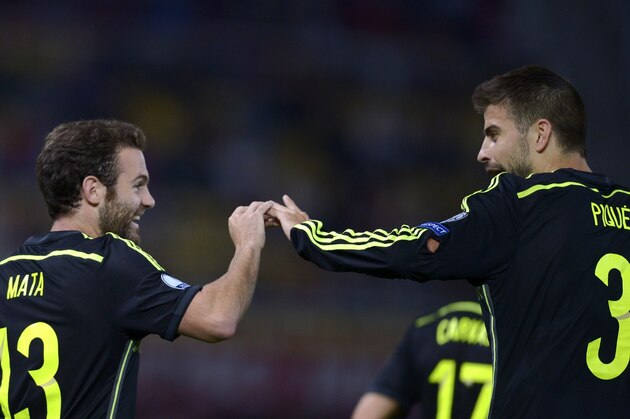 Spain's Midfielder Juan Mata celebrates with his teammate defender Gerard Pique after scoring during the Euro 2016 Group C qualifying football match between Macedonia and Spain at the Filip II Arena stadium in Skopje on September 8, 2015. Spain won the match 0-1.   AFP PHOTO / NIKOLAY DOYCHINOV        (Photo credit should read NIKOLAY DOYCHINOV/AFP/Getty Images)