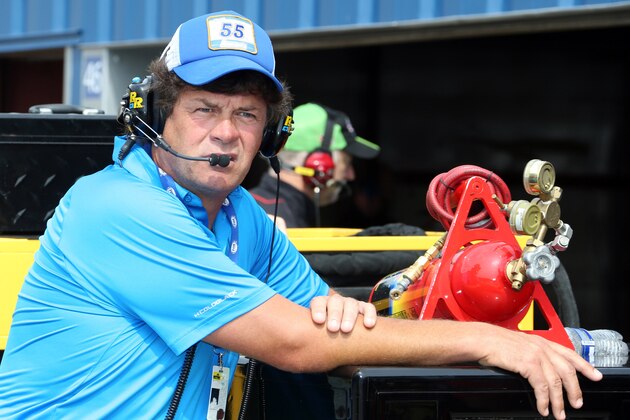 FILE- In this Aug. 14, 2015, file photo, team owner Michael Waltrip watches from outside his garage before a practice session for the NASCAR Sprint Cup series auto race at Michigan International Speedway in Brooklyn, Mich. Waltrip's rocky nine-year effort to build a successful race team was on the verge of collapse Wednesday, Aug. 19, 2015, as the organization said it will not run any cars full-time next season. Driver Clint Bowyer was given a release from his contract to pursue a new job for 2016. (AP Photo/Bob Brodbeck, File)