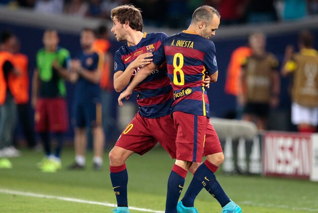 Barcelona's Andres Iniesta, right, is substituted by Barcelona´s Sergi Roberto during the UEFA Super Cup soccer match between FC Barcelona and Sevilla FC at the Boris Paichadze Dinamo Arena stadium, in Tbilisi, Georgia, on Wednesday, Aug. 12, 2015. (AP Photo/Ivan Sekretarev)