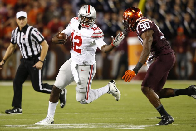 Ohio State quarterback Cardale Jones (12) tries to get past Virginia Tech defensive end Dadi Lhomme Nicolas (90) during the first half of an NCAA college football game in Blacksburg, Va., Monday, Sept. 7, 2015. (AP Photo/Steve Helber)