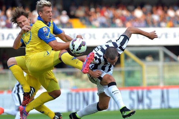 Juventus defender Leonardo Bonucci, right, challenges for the ball with Chievo Verona forward Maxi Lopez during a Serie A soccer match between Chievo Verona and Juventus at the Bentegodi stadium, in Verona, Italy, Saturday, Aug. 30, 2014. (AP Photo/Massimo Pinca)