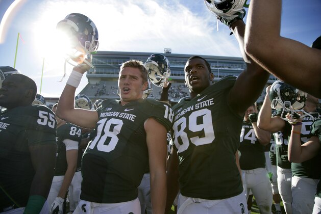 Michigan State quarterback Connor Cook (18) and defensive end Shilique Calhoun (89) and teammates celebrate  following a 55-17 win over Youngstown State in an NCAA college football game, Saturday, Sept. 14, 2013, in East Lansing, Mich. (AP Photo/Al Goldis)