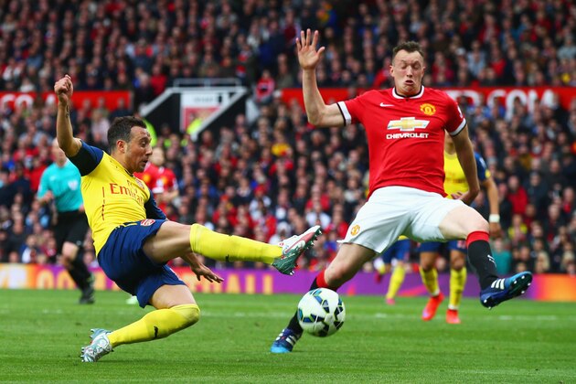 MANCHESTER, ENGLAND - MAY 17:  Santi Cazorla of Arsenal is blocked by Phil Jones of Manchester United during the Barclays Premier League match between Manchester United and Arsenal at Old Trafford on May 17, 2015 in Manchester, England.  (Photo by Clive Rose/Getty Images)