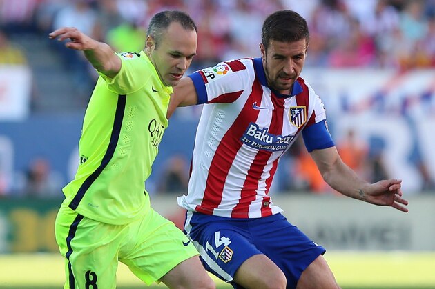 Barcelona's midfielder Andres Iniesta (L) vies with Atletico Madrid's midfielder and captain Gabi during the Spanish league football match Sevilla FC vs UD Almeria at the Ramon Sanchez Pizjuan stadium in Sevilla on May 17, 2015.   AFP PHOTO / CRISTINA QUICLER        (Photo credit should read CESAR MANSO/AFP/Getty Images)