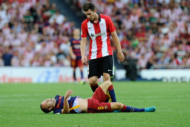 BILBAO, SPAIN - AUGUST 23:   Aymeric Laporte of Club Athletic checks up on Andres Iniesta of FC Barcelona after Iniesta took a knock during the La Liga match between Athletic Club and FC Barcelona at San Mames Stadium on August 23, 2015 in Bilbao, Spain.  (Photo by Denis Doyle/Getty Images)