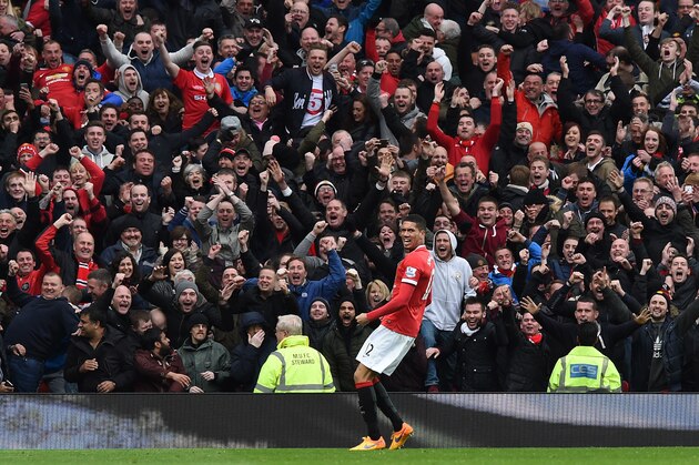 Manchester United's English defender Chris Smalling celebrates after scoring their fourth goal in front of supporters during the English Premier League football match between Manchester United and Manchester City at Old Trafford in Manchester, north west England, on April 12, 2015. Manchester United won the game 4-2. AFP PHOTO / PAUL ELLIS

RESTRICTED TO EDITORIAL USE. NO USE WITH UNAUTHORIZED AUDIO, VIDEO, DATA, FIXTURE LISTS, CLUB/LEAGUE LOGOS OR LIVE SERVICES. ONLINE IN-MATCH USE LIMITED TO 45 IMAGES, NO VIDEO EMULATION. NO USE IN BETTING, GAMES OR SINGLE CLUB/LEAGUE/PLAYER PUBLICATIONS.        (Photo credit should read PAUL ELLIS/AFP/Getty Images)