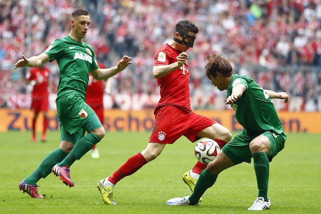 Bayern's Robert Lewandowski from Poland, center, Augsburg's Dominik Kohr, left, and Augsburg's Hong Jeong-ho from South Korea challenge for the ball during the German first division Bundesliga soccer match between FC Bayern Munich and FC Augsburg at the Allianz Arena in Munich, Germany, on Saturday, May 9, 2015. (AP Photo/Matthias Schrader)
