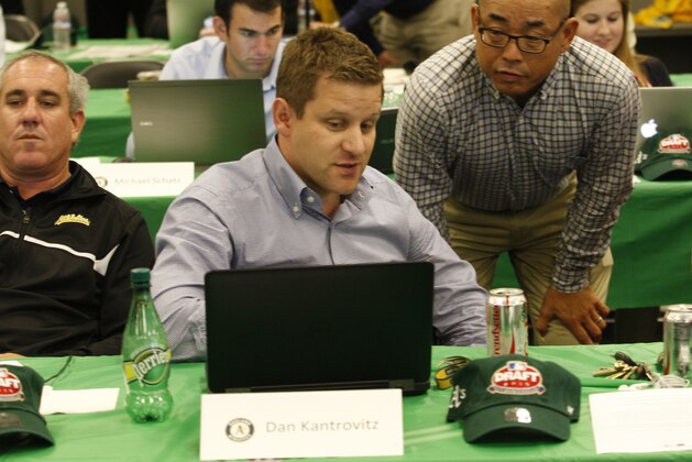 OAKLAND, CA - JUNE 8: Assistant General Manager Dan Kantrovitz, Director of Scouting Eric Kubota, and Assistant General Manager David Forst of the Oakland Athletics talk in the Athletics draft room during the first day of the 2015 MLB Draft at O.co Coliseum on June 8, 2015 in Oakland, California. (Photo by Michael Zagaris/Oakland Athletics/Getty Images)