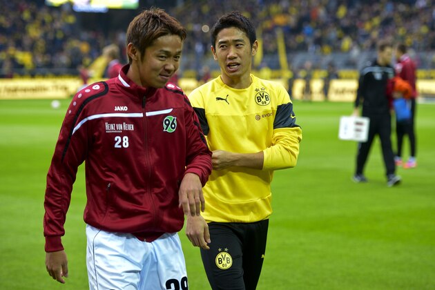 Dortmund's Japanese midfielder Shinji Kagawa (R) and Hanover's Japanese midfielder Hiroshi Kiyotake walk on the pitch during the German First division Bundesliga football match Borussia Dortmund vs Hannover 96 on October 25, 2014 in Dortmund, western Germany. The match ended 0-1.  AFP PHOTO / SASCHA SCHUERMANN

DFL RULES TO LIMIT THE ONLINE USAGE DURING MATCH TIME TO 15 PICTURES PER MATCH. IMAGE SEQUENCES TO SIMULATE VIDEO IS NOT ALLOWED AT ANY TIME. FOR FURTHER QUERIES PLEASE CONTACT DFL DIRECTLY AT + 49 69 650050.        (Photo credit should read SASCHA SCHUERMANN/AFP/Getty Images)