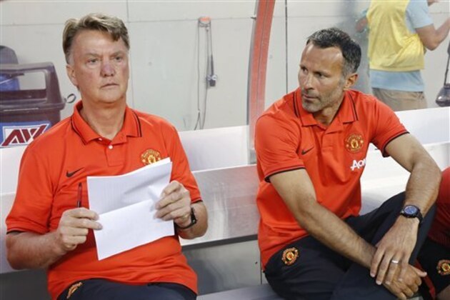 Manchester United head coach Louis van Gaal, left, sits on the bench next to assistant coach Ryan Giggs, right, before the game against the Paris Saint-Germain in an International Champions Cup soccer match on Wednesday, July 29, 2015, in Chicago. Paris Saint-Germain won 2-0. (AP Photo/Kamil Krzaczynski)