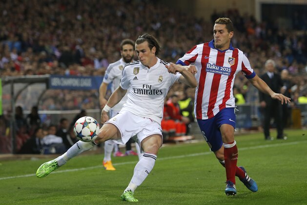 Real Madrid's Gareth Bale fights for the ball against Atletico's Koke during the Champions League quarterfinal first leg soccer match between Atletico Madrid and Real Madrid at the Vicente Calderon stadium in Madrid, Spain, Tuesday, April 14, 2015. (AP Photo/Andres Kudacki)