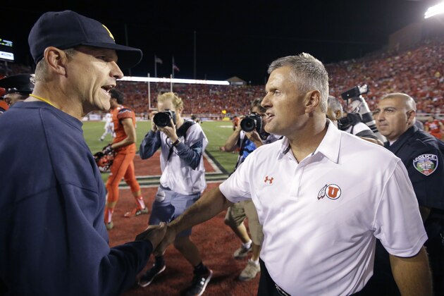 Michigan coach Jim Harbaugh, left, shakes hands with Utah coach Kyle Whittingham, right, at the end of an NCAA college football game, Thursday, Sept. 3, 2015, in Salt Lake City. Utah won 24-17. (AP Photo/Rick Bowmer)